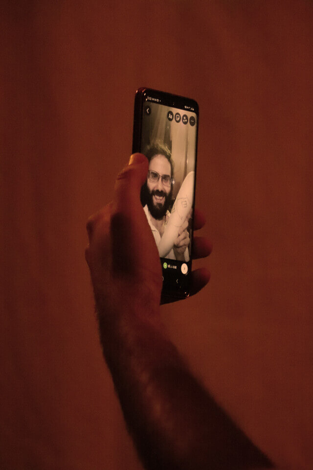 The hand of the performer, stephan e perez, holds a smartphone. On its screen is an Instagram Storys screen with a photo of the performer and Shunsuke, the daikon