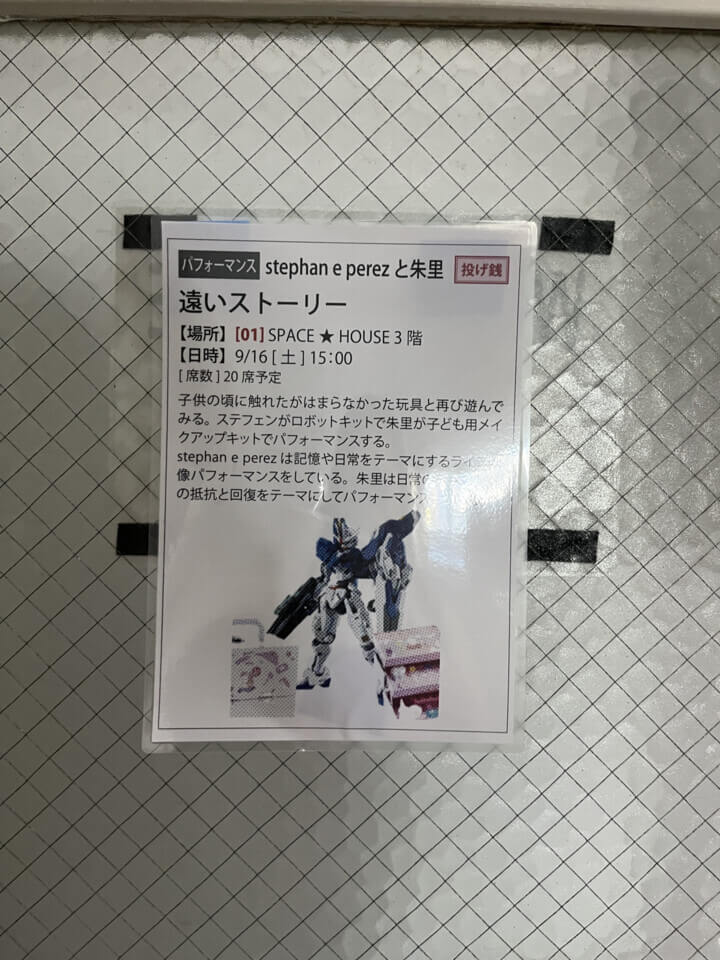 A notice taped to the door of the venue containing the promotional image and the description in Japanese