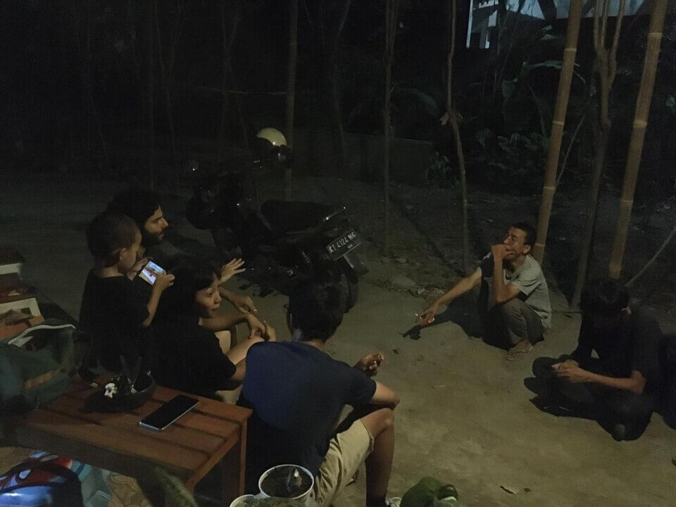 post-performance group discussion. The event guests sit with stephan next to the parked moped